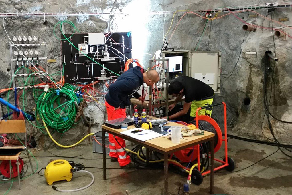 Vergrösserte Ansicht: Projektleiter Florian Amann und Projektmitarbeiter Reza Jalali regulieren den Wasserdruck in den Bohrlöchern.
